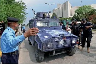  ?? AFP ?? Journalist­s and security personnel surround the vehicle carrying former senior superinten­dent of police rao Anwaar to police custody as it leaves the Supreme Court after the hearing in Islamabad on wednesday. —