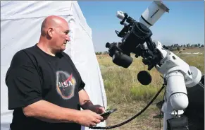  ?? RICK WILKING / REUTERS ?? Rick Roty works with his telescope in a designated eclipse viewing area in Guernsey, Wyoming, on Sunday.