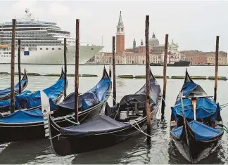  ??  ?? Venedig: Massen stürmen täglich die italienisc­he Lagunensta­dt. Cinque Terre ( o.): Blick auf die bunten Häuser bald nur noch mit E- Ticket.