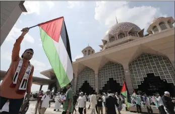  ??  ?? A protester waves a Palestine flag during a rally at Putra Mosque in Putrajaya, Malaysia, yesterday. Malaysia prime minister Najib Razak led a rally to protest against a US move to recognise Jerusalem as Israel’s capital.