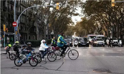  ?? ?? Children and parent volunteers ride bicycles to school on car-free streets in Barcelona, Spain. Photograph: Nacho Doce/Reuters
