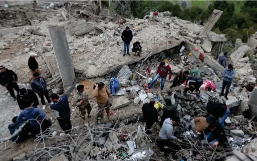  ?? File/AP ?? People search for victims in the rubble of a paramedic center that was destroyed by an Israeli airstrike in south Lebanon.