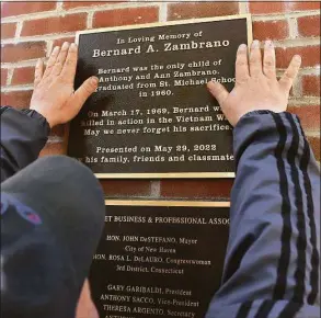  ?? Arnold Gold / Hearst Connecticu­t Media ?? Sami Charachfi installs a plaque dedicated to Bernard Zambrano on the column supporting an arch over Wooster Street in New Haven on Monday. Zambrano died in the Vietnam War on March 17, 1969.