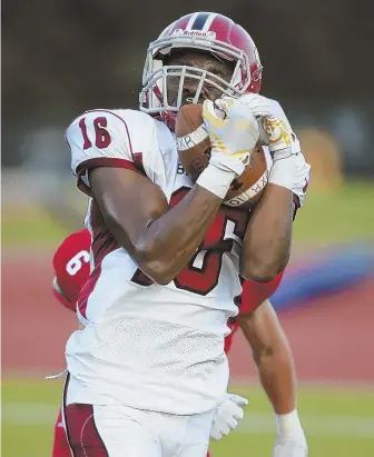  ?? STAFF PHOTO BY NICOLAUS CZARNECKI ?? WITH BOTH HANDS: Brockton’s Isaiah Laguerre makes the catch in the second quarter of a nonleague showdown against Natick last night at Memorial Field in Natick. The Boxers beat the Redhawks, 22-20.