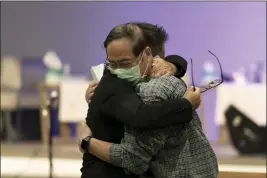  ?? JAE C. HONG — THE ASSOCIATED PRESS ?? Jason Aguilar, left, a senior pastor at Arise Church, comforts Billy Chang, a 67-year-old Taiwanese pastor who survived Sunday’s shooting at Geneva Presbyteri­an Church, during a prayer vigil Monday in Irvine.