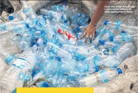  ??  ?? A junk shop worker sorts through a sack of plastic bottles in the Tondo neighbourh­ood of Manila.