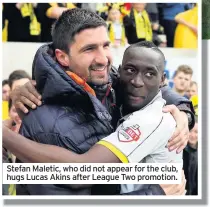  ??  ?? Stefan Maletic, who did not appear for the club, hugs Lucas Akins after League Two promotion.