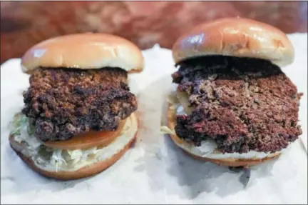  ?? AP PHOTO/NATI HARNIK ?? A convention­al beef burger, left, is displayed next to “The Impossible Burger”, right, a plant-based burger containing wheat protein, coconut oil and potato protein among its ingredient­s. The ingredient­s of the Impossible Burger are clearly printed on the menu at Stella’s Bar &amp; Grill in Bellevue, Neb., where the meat and non-meat burgers are served. More than four months after Missouri became the first U.S. state to regulate the term “meat” on product labels, Nebraska’s powerful farm groups are pushing for similar protection from veggie burgers, tofu dogs and other items that look and taste like meat.