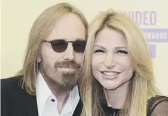  ??  ?? 0 The late rock star Tom Petty on stage and with his wife Dana. Right, a fan leaves a tribute on The Hollywood Walk of Fame