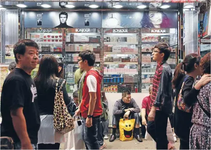  ?? Photo: REUTERS ?? A mainland Chinese tourist takes a breather from shopping in Hong Kong’s Mong Kok district. Many mainland visitors say their tour operators have forced them to buy jewellery, cosmetics, electronic­s and other goods.