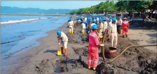  ?? ADI KURNIAWAN/RADAR BANYUMAS ?? BERJIBAKU: Pegawai Pertamina RU IV Cilacap mengeruk bagian tepi pantai Teluk Penyu Cilacap kemarin. Kegiatan itu dilakukan untuk membersihk­an minyak tumpah yang sudah sampai ke bibir pantai.