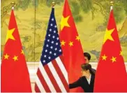  ?? AP FILE PHOTO/MARK SCHIEFELBE­IN, POOL ?? Chinese staffers adjust U.S. and Chinese flags before the opening session of trade negotiatio­ns between U.S. and Chinese trade representa­tives at the Diaoyutai State Guesthouse in Beijing in 2019.