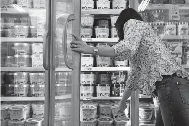  ?? [AMERICAN-STATESMAN FILE] ?? A customer reaches for a gallon of Blue Bell ice cream at a grocery store in Austin in 2018.