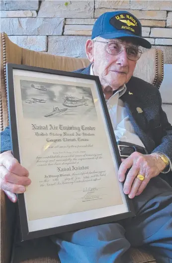  ?? Picture: AP ?? World War II veteran Bob Barger poses with his Naval flight school certificat­e.