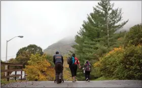  ??  ?? Struggle: An unemployed coal miner walks with his family on their way back to their apartment from the bus stop in Lynch, Ky. From drivers paying more for gas and families bearing heavier child care costs to workers still awaiting decent pay raises to...