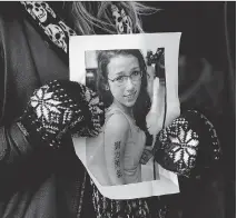  ?? ANDREW VAUGHAN/THE CANADIAN PRESS FILES ?? A woman holds a photo of Rehtaeh Parsons at a memorial. The Halifax teenager committed suicide in 2013 after she was bullied over a sexually explicit photo online.
