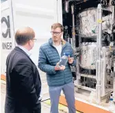  ?? ALEKSANDAR FURTULA/AP ?? Tim Boeltken, director and founder of INERATEC, displays a bottle with e-fuel at the Atmosfair synthetic kerosene plant Monday in Werlte, Germany.