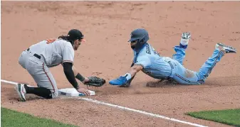  ?? ADRIAN KRAUS, AP ?? Toronto Blue Jays outfielder Lourdes Gurriel Jr. slides safely into third base, beating the tag of Baltimore Orioles third baseman Rio Ruiz during the sixth inning in Buffalo on Monday. The Orioles got RBI doubles from Jose Iglesias and Bryan Holaday in the 11th inning to beat the Jays 4-3.