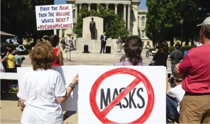  ?? JUSTIN L. FOWLER/THE STATE JOURNAL-REGISTER VIA AP ?? Protesters attend the “Million Unmasked March” at the Illinois State Capitol in July to voice their opposition to guidelines that children be required to wear masks when they return to school.
