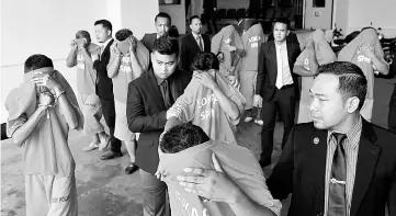  ??  ?? The suspects being escorted at the court complex in Kuantan yesterday. — Bernama photo