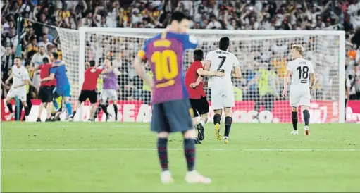  ?? JON NAZCA / REUTERS ?? Los jugadores del Valencia corren para celebrar el título mientras Leo Messi parece no querer verlo