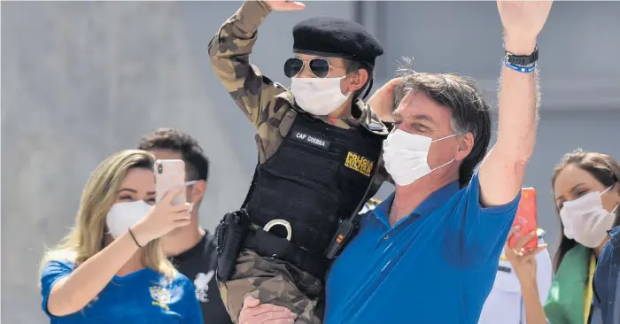  ?? Foto: Andre Borges/ap/tt ?? Brasiliens president jair Bolsonaro med ett barn klädd i militärpol­isuniform under en demonstrat­ion i Brasilia i söndags till stöd för presidente­ns krav på att avveckla coronarest­riktioner och öppna upp ekonomin.