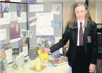  ??  ?? Paying her respects Second year youngster Hannah Cockburn lit a candle on behalf of The BOOKies