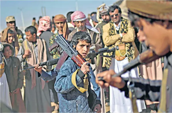  ?? ?? Above: Yemeni boy holds an assault rifle during a gathering organised by the Houthis to recruit more fighters