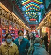  ?? MARK SCHIEFELBE­IN/AP ?? Shoppers eye souvenirs Feb. 28 in Beijing. China’s pandemic recovery and demand in India will drive 2023 growth in Asia, the Asian Developmen­t Bank said.