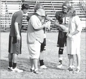  ?? MARK HUMPHREY ENTERPRISE-LEADER ?? Lincoln volunteer assistant coach Perry Philpot (right) confers with head coach Don Harrison and offensive coordinato­r Tyler Dorton during a recent practice.