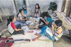  ??  ?? Vincentia Orisa Ratih Prastiwi makes a home visit to students who have poor cellular service and cannot learn online, in Magelang.