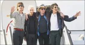  ?? Ramon Espinosa / Associated Press ?? In this March 24, 2016, photo, members of The Rolling Stones, from left, Mick Jagger, Charlie Watts, Keith Richards and Ron Wood pose for photos from their plane at Jose Marti internatio­nal airport in Havana, Cuba.