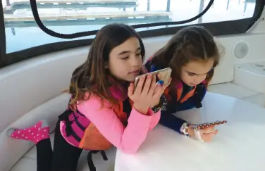  ??  ?? The author’s daughters, Molly and Madelyn, were happily connected to YouTube during a 14-month cruise on the family’s Carver Voyager 57.