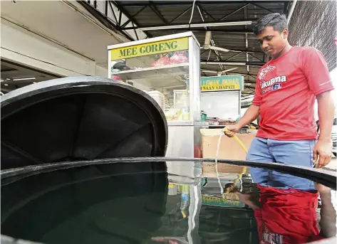  ?? — AZMAN GHANI/ The Star ?? Not taking chances: Md Alamin, an employee at Restoran Ali Bistro’s employee near Jalan Segambut Pusat, storing water before the start of the water disruption.