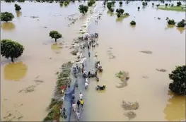  ?? Associated Press ?? HADEJIA, Nigeria, is flooded last year after heavy rain. Debate over emissions goals and financial aid to developing nations held up a U.N. climate change report.