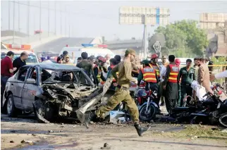  ??  ?? Rescue workers and policemen gather after a suicide blast in Lahore, Pakistan on Monday. (Reuters)