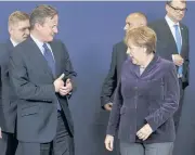  ?? REUTERS ?? Britain’s Prime Minister David Cameron talks to Germany’s Chancellor Angela Merkel as they leave a group photo session during a European Union leaders summit in Brussels, Belgium, on Thursday.