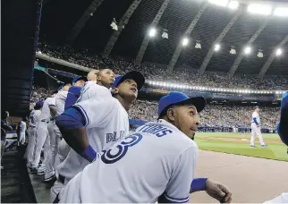  ?? ALLEN MCINNIS/MONTREAL GAZETTE FILES ?? Some of the Blue Jays watch as a pop fly sails in to the stands during a preseason game against the New York Mets at Olympic Stadium on March 28, 2014.