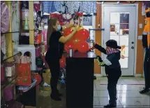  ?? ANDA CHU — STAFF PHOTOGRAPH­ER ?? Alicia Infante creates an organic balloon bouquet while her son Matthew Infante, 7, helps out at her La Herradura Ranch Style Wear shop in East San Jose on Jan. 15.