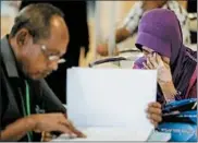  ?? FAZRY ISMAIL/EPA ?? Sarah Nor, right, the mother of a passenger on missing Malaysia Airlines Flight MH370, cries Monday as her husband reads the Safety Investigat­ion Report.