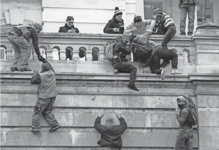  ?? JOSE LUIS MAGANA, AP ?? Insurrecti­onists loyal to then President Donald Trump climb the west wall of the the U.S. Capitol on Jan. 6, 2021, in Washington.