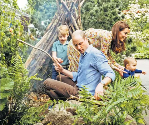  ??  ?? The Duke and Duchess of Cambridge with their children in the woodland wonderland the Duchess has designed for the Chelsea Flower Show. Right, Louis clutches a long stick and toddles towards the photograph­er: his first steps captured on camera