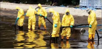  ?? Photo: Pornprom Satrabhaya / Bangkok Post ?? Workers cleaning up the oil-stained Mae Ramphueng beach in Rayong province last Saturday (Jan 29).