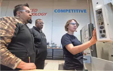  ?? MARK HOFFMAN / JOURNAL SENTINEL ?? Autumn Watkins (right) works with fellow CNC machinists Rogelio Bedolla (left) and Paul Bruce at the SC Johnson iMET Center in Sturtevant. See video at jsonline.com/news.