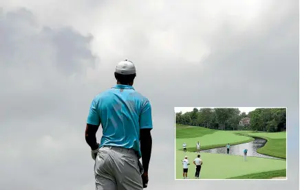  ?? AP ?? Tiger Woods watches his drive from the fifth tee, above, then (inset) putts out in splendid isolation at the Memorial golf tournament in Dublin, Ohio.