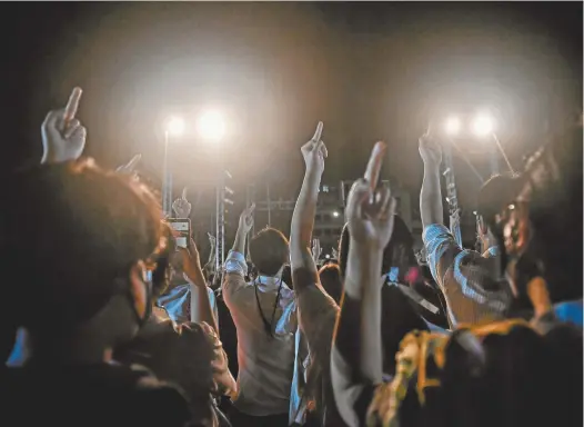  ?? Lillian Suwanrumph­a / AFP ?? Protesters raise middle fingers to Thailand’s Prime Minister Prayuth Chan-ocha during an anti-government rally in Nakhon Pathom this week.