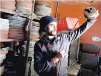  ?? — Reuters ?? A Palestinia­n worker checks a film roll in a former cinema, in Tulkarm in the Israeli-occupied West Bank.