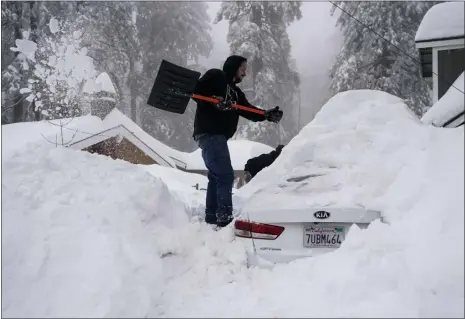  ?? JAE C. HONG — THE ASSOCIATED PRESS ?? Kenny Rybak, 31, shovels snow around his car in Running Springs, Calif., on Tuesday. Beleaguere­d California­ns got hit again Tuesday as a new winter storm moved into the already drenched and snow-plastered state, with blizzard warnings blanketing the Sierra Nevada and forecaster­s warning residents that any travel was dangerous.