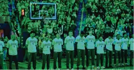  ?? CARLOS OSORIO / AP ?? The Michigan State team stands during a moment of silence before the first half of a game against Michigan on Saturday in Ann Arbor. Michigan honored the victims of the MSU shooting Monday that killed three and injured five.