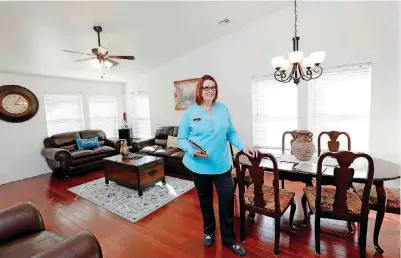 ?? [PHOTOS BY JIM BECKEL, THE OKLAHOMAN] ?? Kathy Fowler, 2018 president of the Oklahoma Associatio­n of Realtors, shows the living-dining area of a home she has listed at 9744 SW 27 for $154,990.